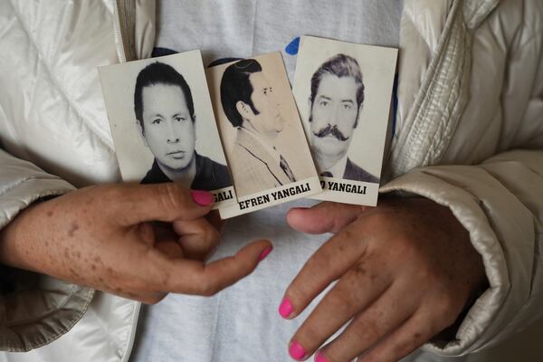 Luyeva Yangali shows photos of her father, right, and uncles, who were disappeared in 1983 during Peru's internal armed conflict, in Lima, Peru, Sunday, Oct. 20, 2024. (AP Photo/Guadalupe Pardo)