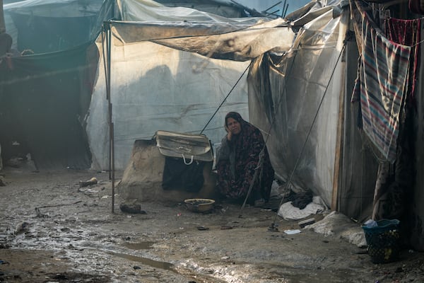 Samira Deifallah, 52, displaced from Gaza city, sits outside her tent after a night of heavy rainfall at a tent camp for displaced Palestinians in Deir al-Balah, central Gaza Strip, Thursday Jan. 23, 2025. (AP Photo/Abdel Kareem Hana)