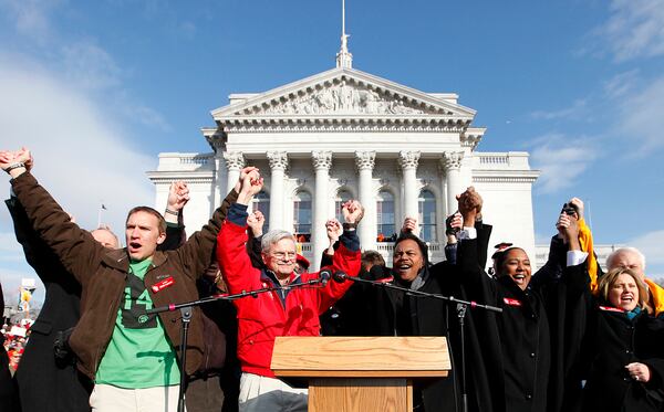 FILE - Members of the 14 Wisconsin Democratic state senators who spent more than three weeks in Illinois protesting Wisconsin Gov. Scott Walker's budget repair bill, appear before supporters during a rally at the State Capitol, in Madison, March 12, 2011. (AP Photo/Wisconsin State Journal, John Hart, File)