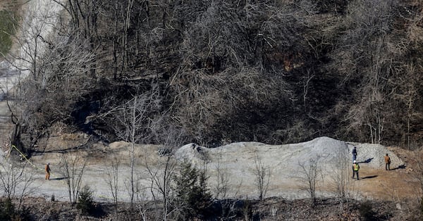 FILE - Officials stand on one edge of a giant sinkhole on the property of the Louisville Zoo, Wednesday, March 6, 2019, in Louisville, Ky. (Jeff Faughender/Courier Journal via AP, File)