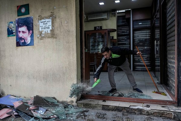 A man clears broken glass from his damaged shop near a building hit on Monday evening by an Israeli airstrike in central Beirut, Lebanon, Tuesday, Nov. 19, 2024. (AP Photo/Bilal Hussein)