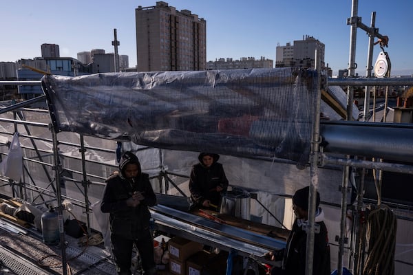 Roofers work on zinc sheets on the roof of a building in Paris, Wednesday, Nov. 20, 2024. (AP Photo/Louise Delmotte)