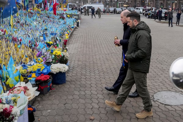 Ukraine's President Volodymyr Zelenskyy, right, and German Chancellor Olaf Scholz attend a ceremony of honoring fallen soldiers near the People's Memorial of National Memory in Kyiv, Ukraine, Monday, Dec.2, 2024. (AP Photo/Evgeniy Maloletka)