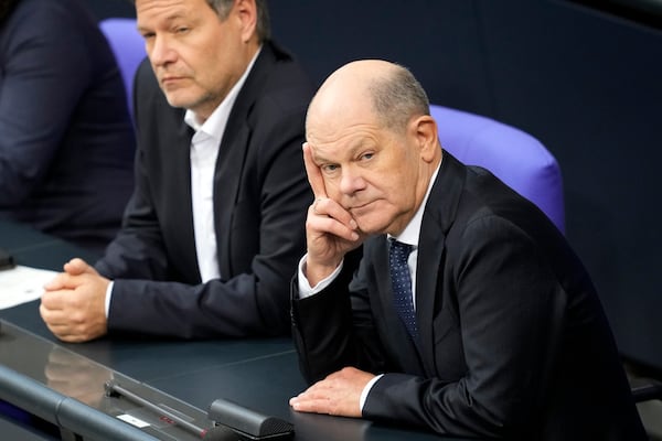 German Chancellor Olaf Scholz, right, listens to the speech of Friedrich Merz, German opposition leader and chairman of the Christian Democratic Union (CDU) party, speaking during a session of the German parliament 'Bundestag' in Berlin, Germany, Friday, Jan. 31, 2025. (AP Photo/Ebrahim Noroozi)