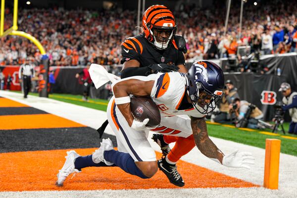 Denver Broncos wide receiver Courtland Sutton (14) makes a catch for a touchdown in front of Cincinnati Bengals cornerback Josh Newton (28) during the second half of an NFL football game in Cincinnati, Saturday, Dec. 28, 2024. (AP Photo/Jeff Dean)