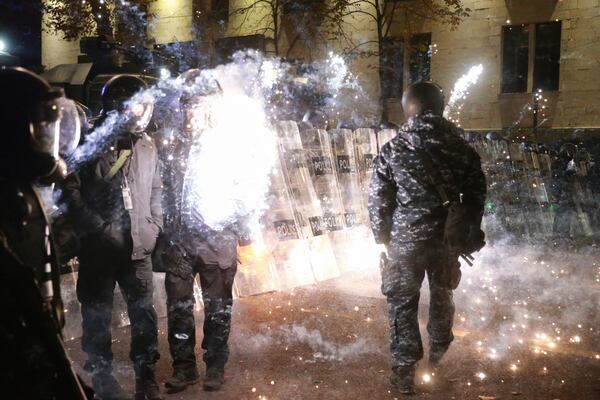 A firecracker launched by demonstrators explodes hitting a policeman during a rally to protest against the government's decision to suspend negotiations on joining the European Union in Tbilisi, Georgia, early Tuesday, Dec. 3, 2024. (AP Photo/Zurab Tsertsvadze)