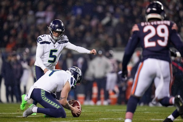 Seattle Seahawks place kicker Jason Myers (5), with Michael Dickson holding, kicks a field goal against the Chicago Bears during the first half of an NFL football game, Thursday, Dec. 26, 2024, in Chicago. (AP Photo/Erin Hooley)