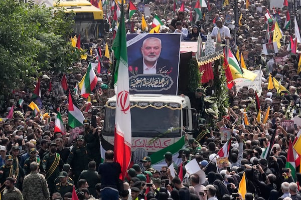 FILE - Iranians follow a truck carrying the coffins of Hamas leader Ismail Haniyeh and his bodyguard who were killed in an Israeli assassination during their funeral ceremony at Enqelab-e-Eslami (Islamic Revolution) Sq. in Tehran, Iran, Aug. 1, 2024. (AP Photo/Vahid Salemi, File)