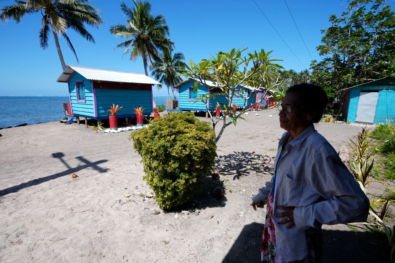 Netina Malae stands in the shade at her Sima PJ Beach Fale resort in the village of Tafitoala, Samoa, on Monday, Oct. 21, 2024, near where a New Zealand navy ship ran aground and sank on Oct. 6. (AP Photo/Rick Rycroft)