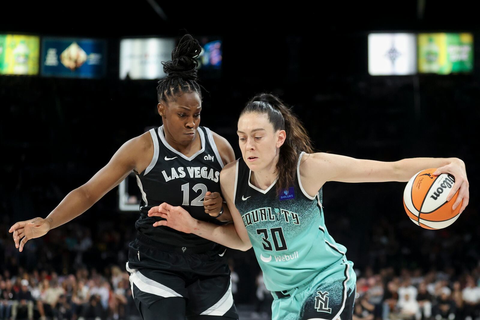 New York Liberty forward Breanna Stewart (30) drives past Las Vegas Aces guard Chelsea Gray (12) during the second half of a WNBA Semifinal basketball game Sunday, Oct. 6, 2024, in Las Vegas. (AP Photo/Ian Maule)