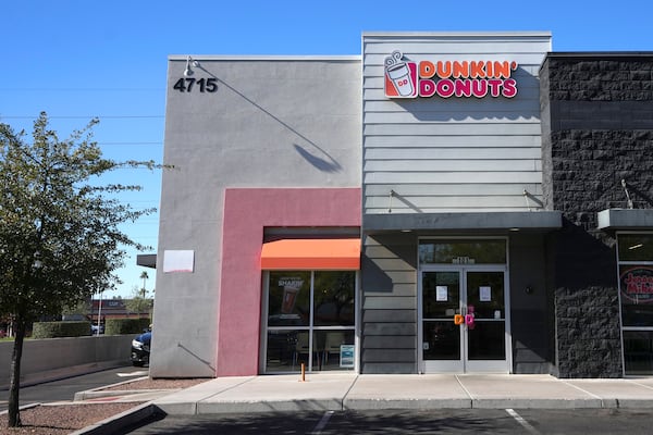 Signs on the doors of a Dunkin' Donuts restaurant explains that customers will find limited doughnut selections for sale Friday, Jan. 10, 2025, in Tempe, Ariz. (AP Photo/Ross D. Franklin)