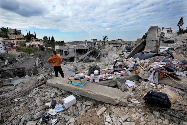 A person stands next to remains and his family destroyed house after he returned to Chehabiyeh village, southern Lebanon, Thursday, Nov. 28, 2024 following a ceasefire between Israel and Hezbollah that went into effect on Wednesday. (AP Photo/Hussein Malla)