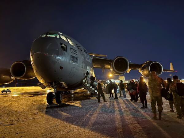 Participants in the Operation Santa program board an Alaska Air National Guard C-17 Globemaster III at Joint Base Elmendorf-Richardson, Alaska, to deliver Santa and Mrs. Claus to Yakutat, Alaska, Wednesday, Dec. 18, 2024. (AP Photo/Mark Thiessen).