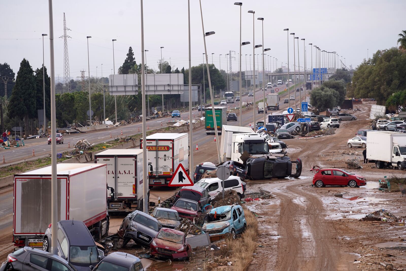 Cars are strewn on the side on a main road after floods in Valencia, Spain, Friday, Nov. 1, 2024. (AP Photo/Alberto Saiz)