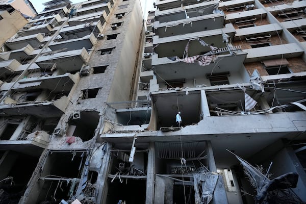 A woman looks through her damaged apartment which was resulted from Sunday's Israeli airstrike in Dahiyeh, in the southern suburb of Beirut, Lebanon, Monday, Nov. 25, 2024. (AP Photo/Hussein Malla)