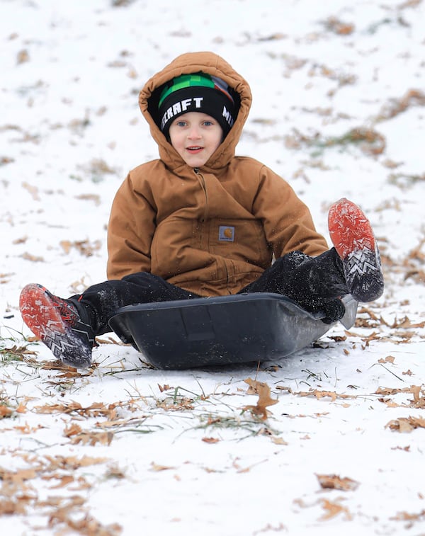 Taking advantage of the lingering ice and snow from the recent winter weather event, Dawson Mauro, 6, races down a steep hill behind Chautauqua Park while sledding, Wednesday, Jan. 8, 2025, in Owensboro, Ky. (Greg Eans/The Messenger-Inquirer via AP)