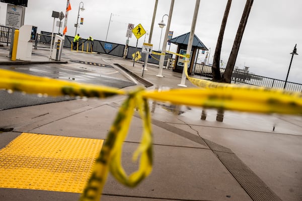 Caution tape hangs near the entrance of the closed Santa Cruz Wharf after a section of the wharf collapsed into the Pacific Ocean amidst heavy surf Monday in Santa Cruz, Calif., Tuesday, Dec. 24, 2024. (Stephen Lam/San Francisco Chronicle via AP)