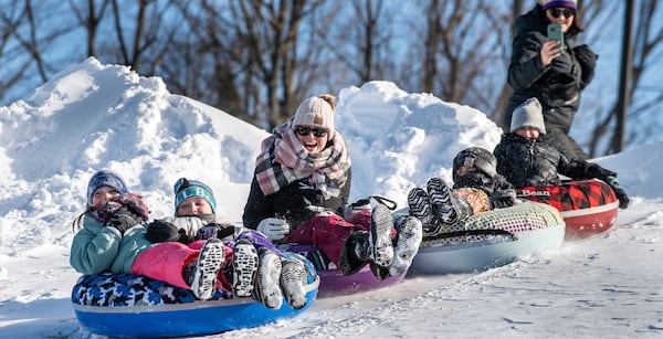 Friends and family enjoy a fun morning tubing down the hill behind Sherwood Heights Elementary School Auburn, Maine, Monday, Jan. 20, 2025. (Russ Dillingham/Sun Journal via AP)