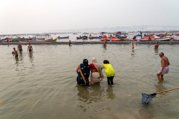 A family enters the water to take a dip at the confluence of the Ganges, the Yamuna and the mythical Saraswati rivers, a day before the official beginning of the 45-day-long Maha Kumbh festival, in Prayagraj, India, Sunday, Jan. 12, 2025. (AP Photo/Ashwini Bhatia)