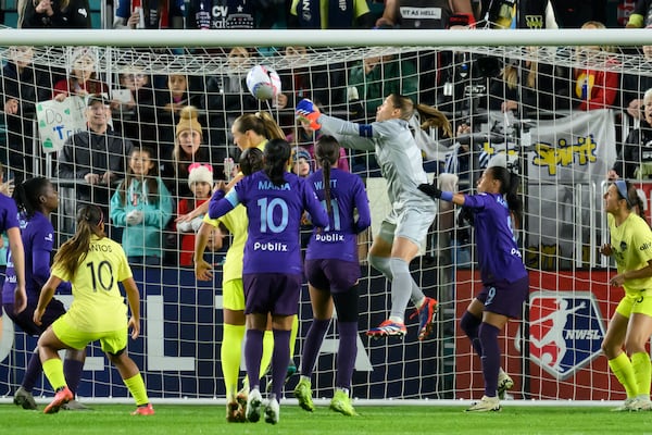 Washington Spirit goalkeeper Aubrey Kingsbury, in grey, clears the ball during the first half of the NWSL championship at CPKC Stadium against the Orlando Pride, Saturday, November 23, 2024, in Kansas City, Mo. (AP Photo/Reed Hoffmann)