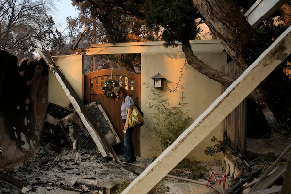 Glenda, who declined to give her last name, stands near the entrance of her home destroyed by the Eaton fire Thursday, Jan. 9, 2025, in Altadena, Calif. (AP Photo/John Locher)