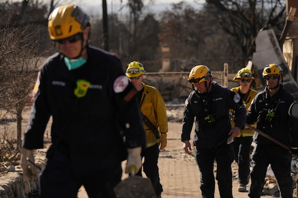 Search and rescue workers dig through the rubble left behind by the Eaton Fire, in Altadena, Calif., Tuesday, Jan. 14, 2025. (AP Photo/Jae C. Hong)