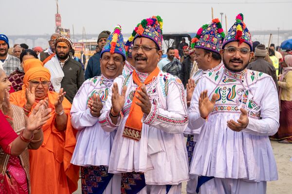 Hindu devotees wearing the ceremonial costume of the Kathiawar region in Gujarat state, sing hymns at the confluence of the Ganges, the Yamuna and the mythical Saraswati rivers, a day before the official beginning of the 45-day-long Maha Kumbh festival, in Prayagraj, India, Sunday, Jan. 12, 2025. (AP Photo/Ashwini Bhatia)