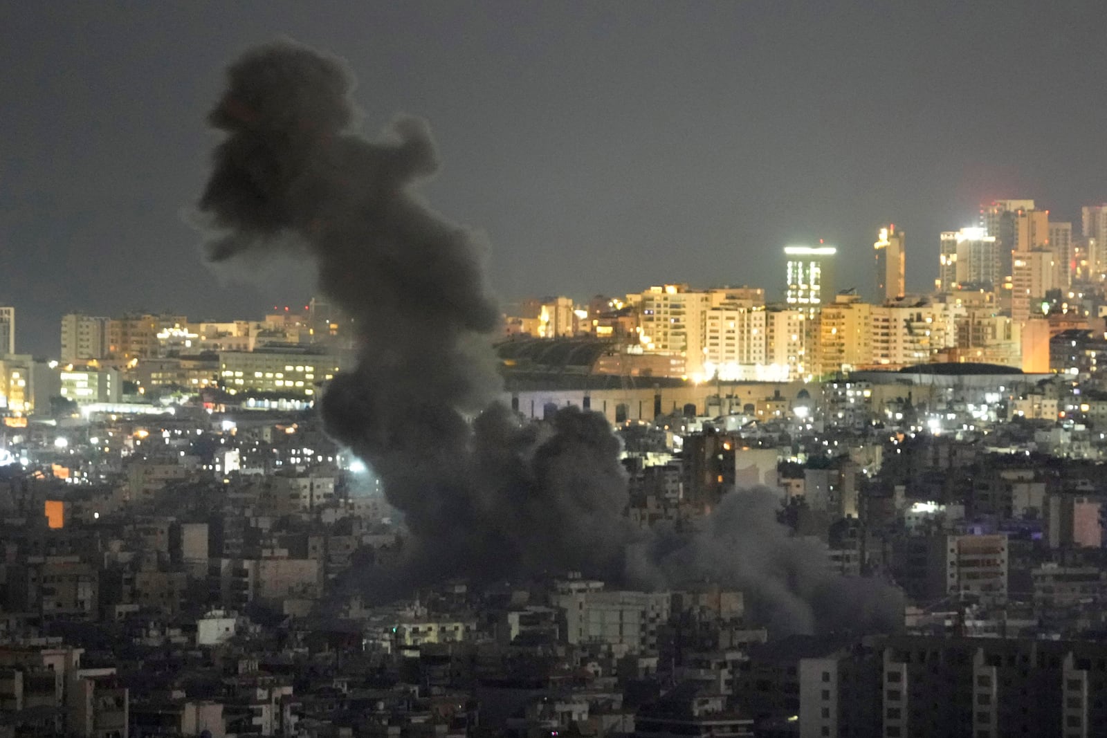 Smoke rise from an Israeli airstrike on Dahiyeh in the southern suburb of Beirut, as Beirut city seen in the background, Lebanon, Sunday, Oct. 20, 2024. (AP Photo/Hussein Malla)