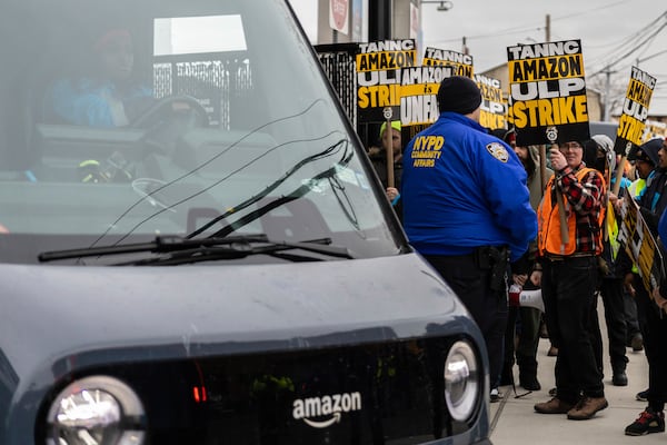 Amazon workers and members of the International Brotherhood of Teamsters picket in front of the Amazon fulfillment center in the Queens borough of New York, Friday, Dec. 20, 2024. (AP Photo/Stefan Jeremiah)