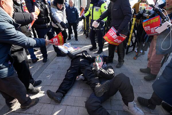 Demonstrators supporting, bottom left, and opposing impeached South Korean President Yoon Suk Yeol lie down on the ground near the presidential residence in Seoul, South Korea, Friday, Jan. 10, 2025. (AP Photo/Ahn Young-joon)