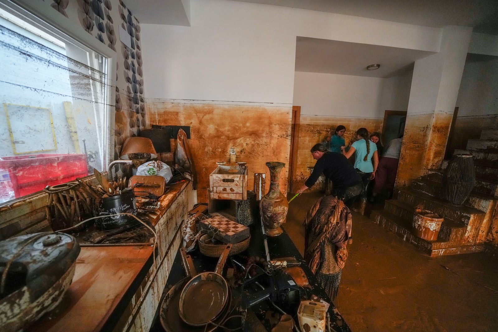 People clean their house affected by floods in Utiel, Spain, Wednesday, Oct. 30, 2024. (AP Photo/Manu Fernandez)