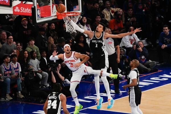 San Antonio Spurs' Victor Wembanyama (1), top right, commits goaltending on a shot put up by New York Knicks' Josh Hart (3), top left, during the first half of an NBA basketball game, Wednesday, Dec. 25, 2024, in New York. (AP Photo/Seth Wenig)