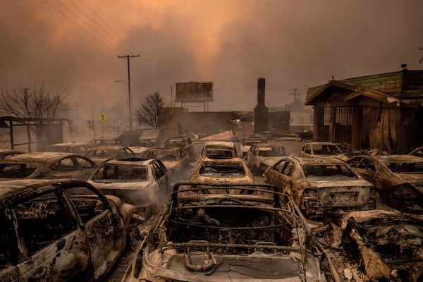 Fire-damaged vehicles are lined up at a dealership after the Eaton Fire swept through Wednesday, Jan. 8, 2025, in Altadena, Calif. (AP Photo/Ethan Swope)