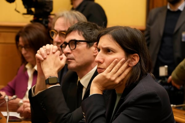 Italian Democratic part Leader Elly Schlein listens to David Yambio, of South Sudan, during a press conference at the Chamber of Deputies where he is recounting his experience in the Libyan prisons, in Rome, Wednesday, Jan. 29, 2025. (AP Photo/Gregorio Borgia)