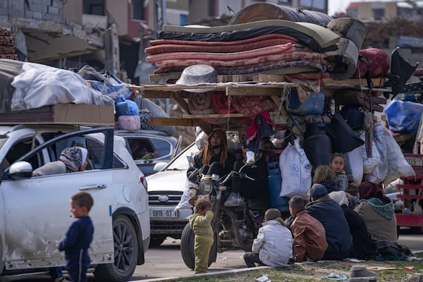 Displaced Palestinians with their belongings gather near a roadblock on Salah al-Din Street, as they wait to return to their homes in the northern part of the Gaza Strip, Sunday, Jan. 26, 2025, days after the ceasefire deal between Israel and Hamas came into effect. (AP Photo/Abdel Kareem Hana)