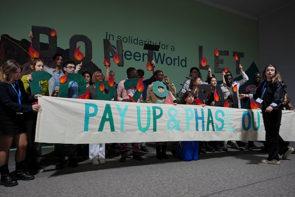 Activist Luisa Neubauer, of Germany, right, leads a demonstration against fossil fuels at the COP29 U.N. Climate Summit, Friday, Nov. 15, 2024, in Baku, Azerbaijan. (AP Photo/Peter Dejong)