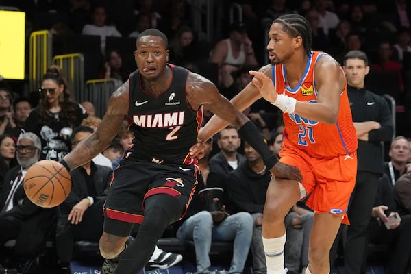 Oklahoma City Thunder guard Aaron Wiggins (21) defends Miami Heat guard Terry Rozier (2) during the first half of an NBA basketball game, Friday, Dec. 20, 2024, in Miami. (AP Photo/Marta Lavandier)