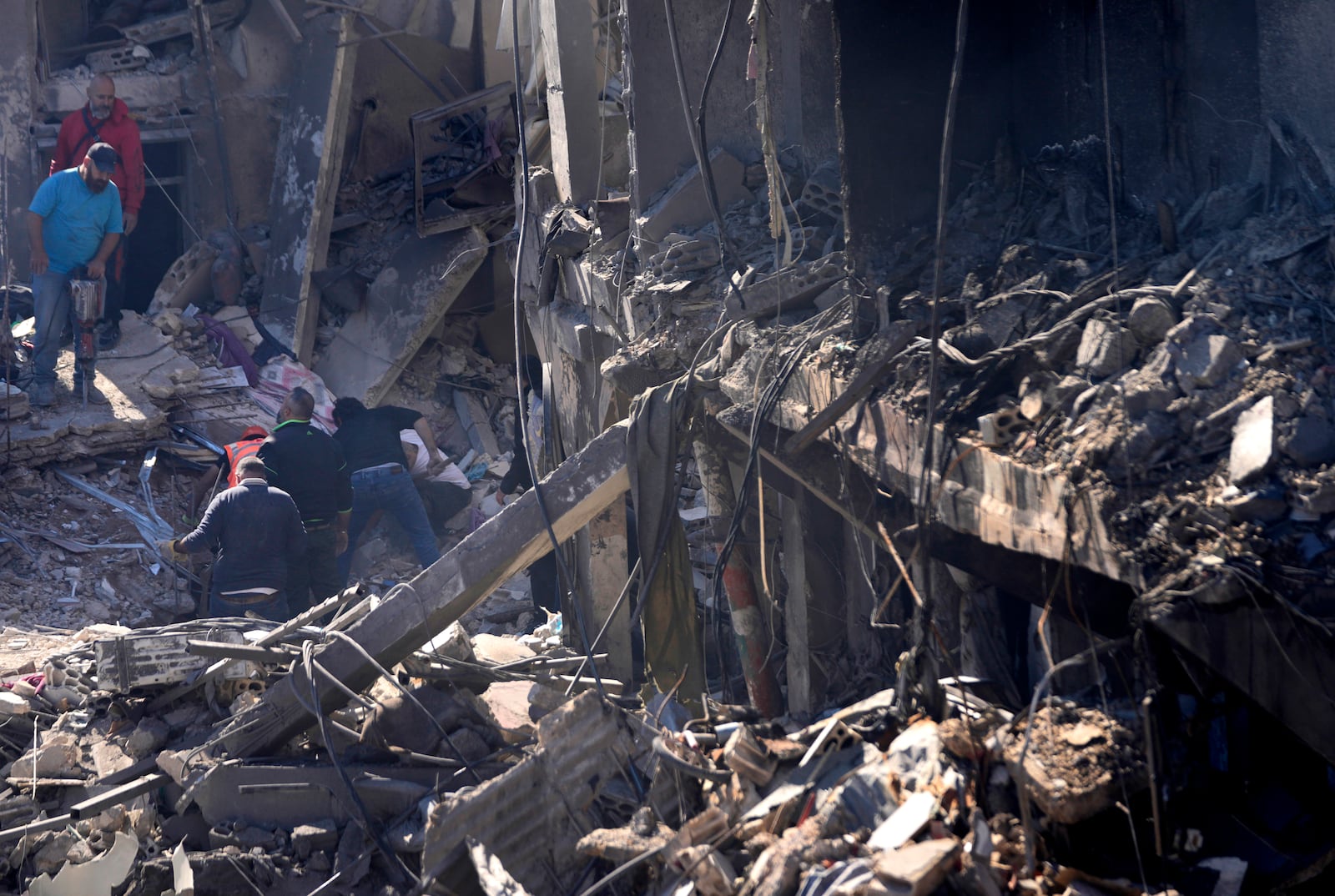 Rescue workers search for victims at the site of Israeli airstrikes that destroyed buildings facing the city's main government hospital in a densely-populated neighborhood, in southern Beirut, Lebanon, Tuesday, Oct. 22, 2024. (AP Photo/Hussein Malla)