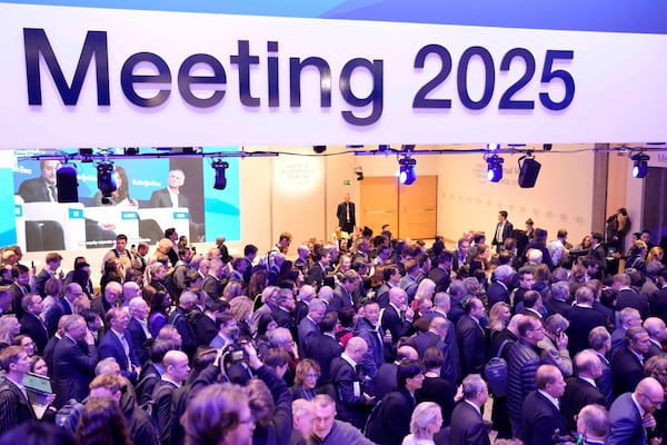 People arrive for the virtual speech of U.S. president Donald Trump at the Annual Meeting of World Economic Forum in Davos, Switzerland, Thursday, Jan. 23, 2025. (AP Photo/Markus Schreiber)