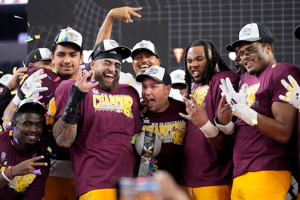 Ariona State head coach Kenny Dillingham, center, celebrates with his team after their win in the Big 12 Conference championship NCAA college football game against Iowa State, in Arlington, Texas, Saturday Dec. 7, 2024. (AP Photo/LM Otero)