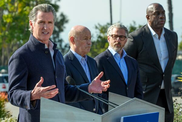 California Gov. Gavin Newsom, left, holds a news conference with Dodgers President and CEO Stan Kasten, from third right, 2028 Olympics organizer Casey Wasserman and Magic Johnson, at Dodger Stadium to announce a new private-sector initiative called LA Rises aimed to support rebuilding efforts after the devastating wildfires in Los Angeles, Tuesday, Jan. 28, 2025. (AP Photo/Damian Dovarganes)