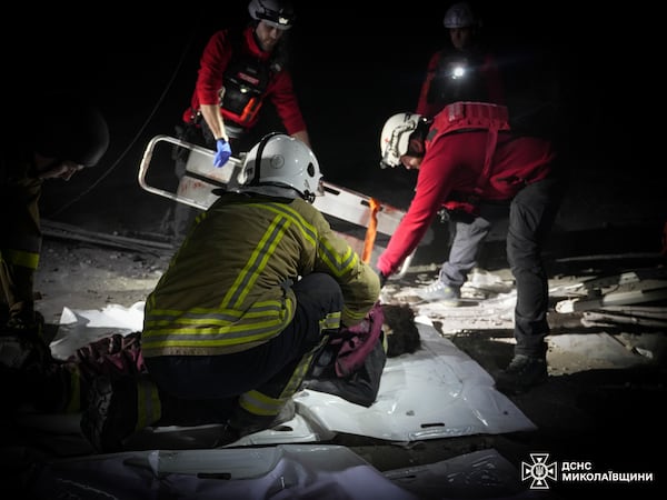 In this photo provided by the Ukrainian Emergency Service, rescuers unblock the body of a civilian who was killed when a Russian drone hit a city food factory in Mykolaiv, Ukraine, Wednesday, Jan. 29, 2025. (Ukrainian Emergency Service via AP)