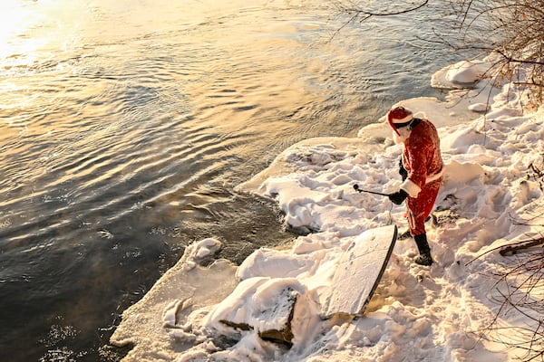 Carlos Hebert Plante, who boogie boards daily, dressed as Santa Claus gets ready to hit the St-Lawrence River amid an air temperature of -14 degrees Celsius on Christmas Day, in Montreal, Wednesday, Dec. 25, 2024. (Bernard Brault /The Canadian Press via AP)