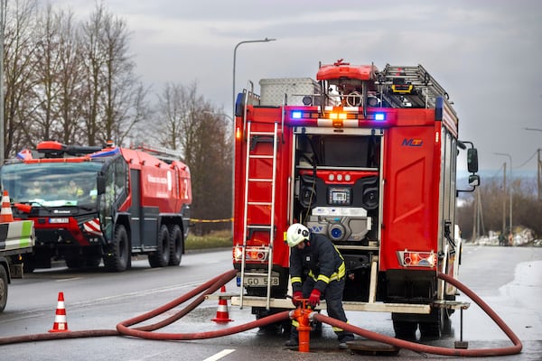 Lithuanian emergency personnel prepare to work near the site where a DHL cargo plane crashed into a house near the Lithuanian capital Vilnius, Lithuania, Monday, Nov. 25, 2024. (AP Photo/Mindaugas Kulbis)