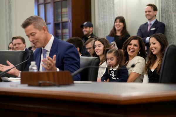 With his family sitting behind him, former Wisconsin Rep. Sean Duffy, R-Wis., testifies before the Senate Commerce, Science, and Transportation Committee on Capitol Hill in Washington, Wednesday, Jan. 15, 2025, for his nomination to be Transportation Secretary. (AP Photo/Susan Walsh)