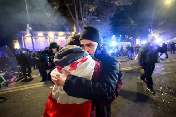 Two demonstrators embrace each other after police pushed away protesters pouring into the streets following Georgian Prime Minister Irakli Kobakhidze's announcement, rallying outside the parliament building in Tbilisi, Georgia, on Friday, Nov. 29, 2024. (AP Photo/Zurab Tsertsvadze)