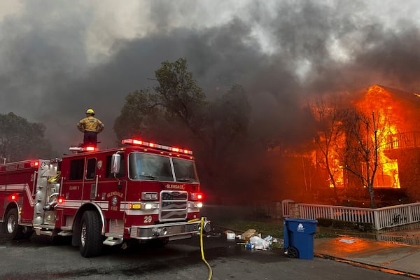 Firefighters battle the Palisades Fire as it burns structures in the Pacific Palisades neighborhood of Los Angeles, Wednesday, Jan. 8, 2025. (AP Photo/Eugene Garcia)