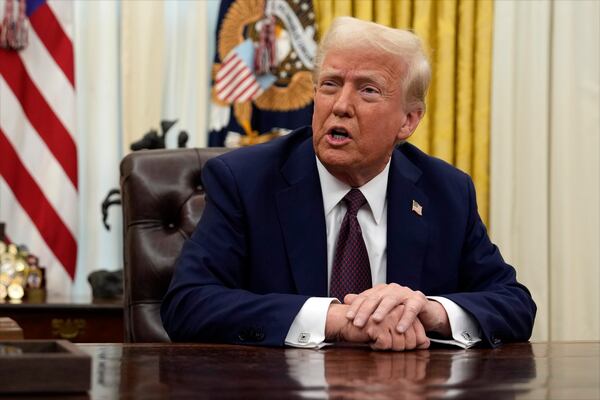 President Donald Trump answers questions from reporters as he signs an executive orders in the Oval Office of the White House, Thursday, Jan. 23, 2025, in Washington. (AP Photo/Ben Curtis)