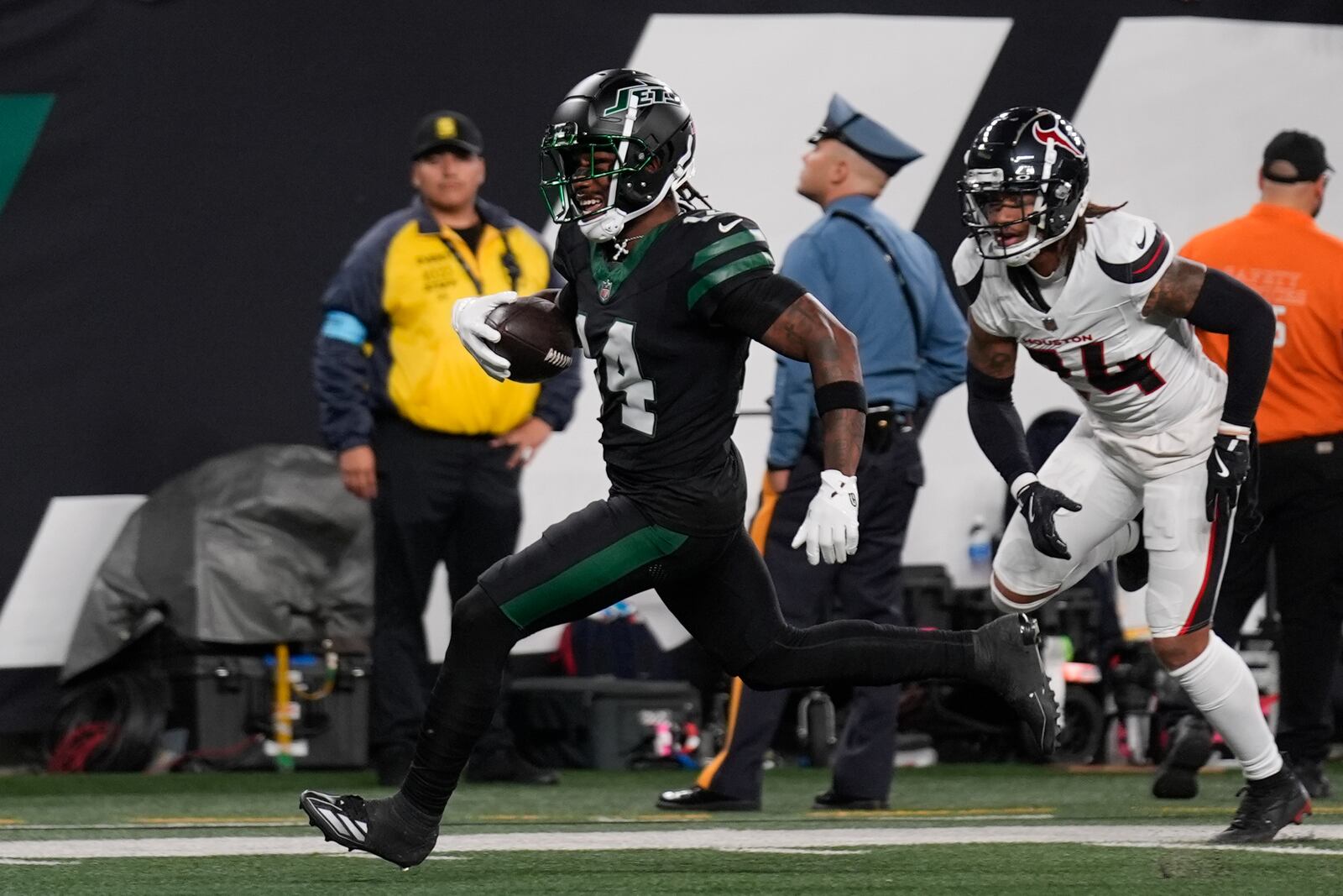 New York Jets wide receiver Malachi Corley (14) runs to the end zone before dropping the ball as Houston Texans cornerback Derek Stingley Jr. (24) defends during the first half an NFL football game Thursday, Oct. 31, 2024, in East Rutherford, N.J. (AP Photo/Seth Wenig)