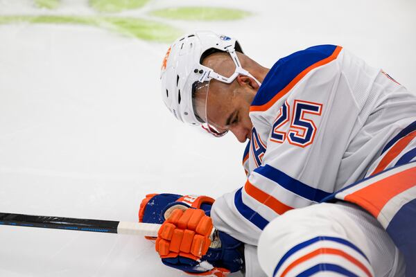 Edmonton Oilers defenseman Darnell Nurse (25) lays on the ice after colliding with Toronto Maple Leafs right wing Ryan Reaves (75) during the second period of an NHL hockey game, Saturday, Nov. 16, 2024 in Toronto. (Christopher Katsarov/The Canadian Press via AP)